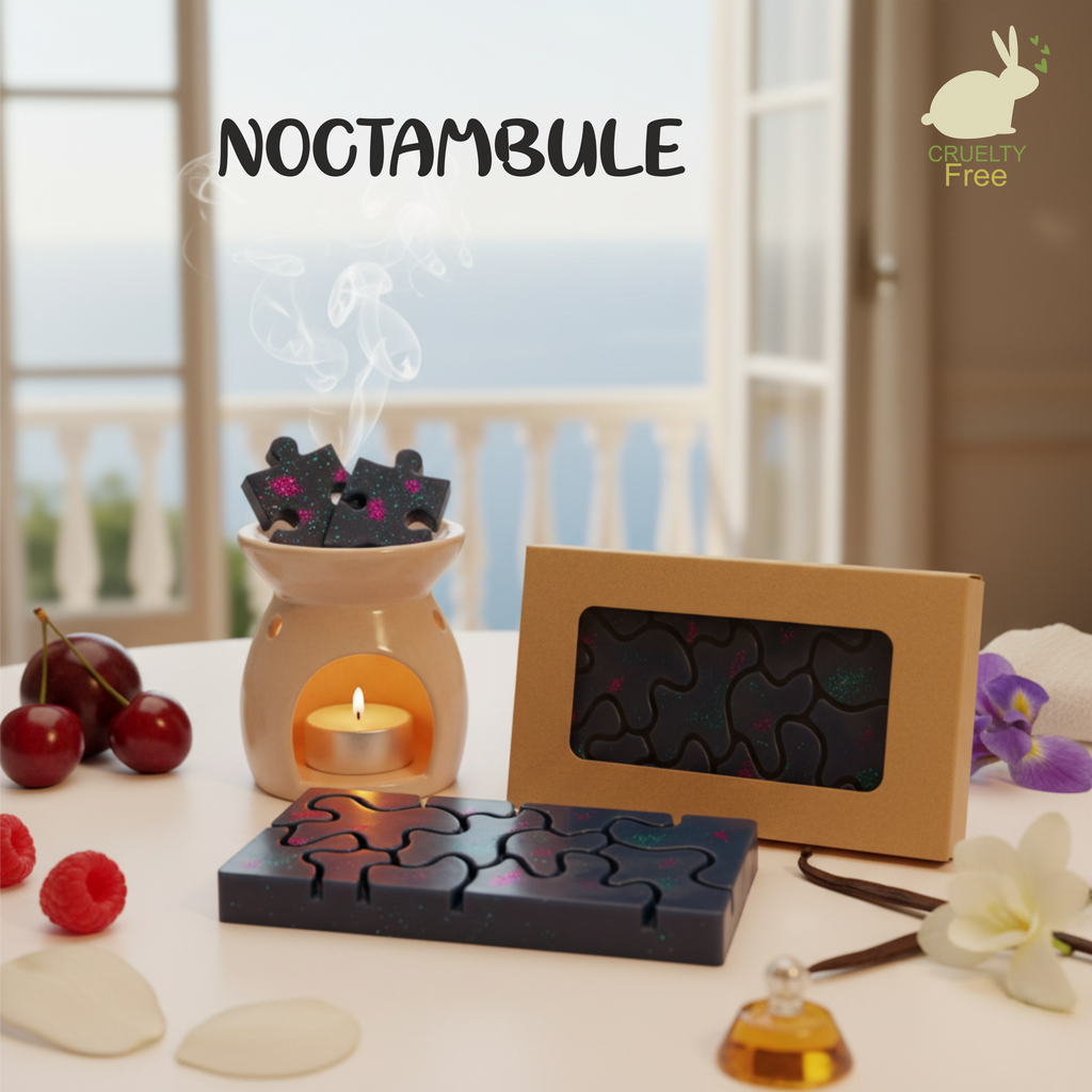 la photo présente une Tablette de fondants parfumés, couleur noir et fuschia, en cire d'olive naturelle, sans produits chimiques, vegan, fragrances proches du parfum "one million", emballée dans un étui couleur kraft avec fenêtre transparente pour voir le produit à l'intérieur. On voit également sur la photo des framboises, cerises, vanille et freesia et un brule parfum blanc duquel s'élèvent des effluves envoutantes